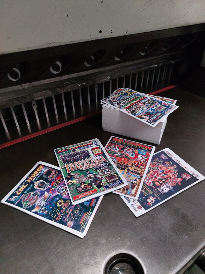 Abanico de flyers de rodeo baile y lucha libre impresos a todo color sobre una pila de papel