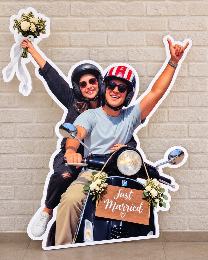 Figura impresa y recortada en coroplast con la forma de una pareja en moto y letrero Just Married